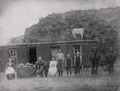 American pioneer family in front of their home by American Photographer